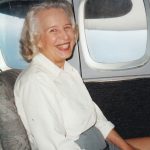 A woman sitting in the back of an airplane.
