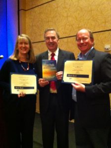 Three people holding certificates and smiling for a picture.
