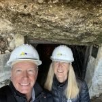 Two people wearing hard hats in a cave.